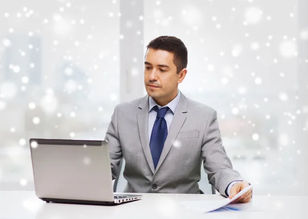 Zakenman met laptop en papieren — Stockfoto