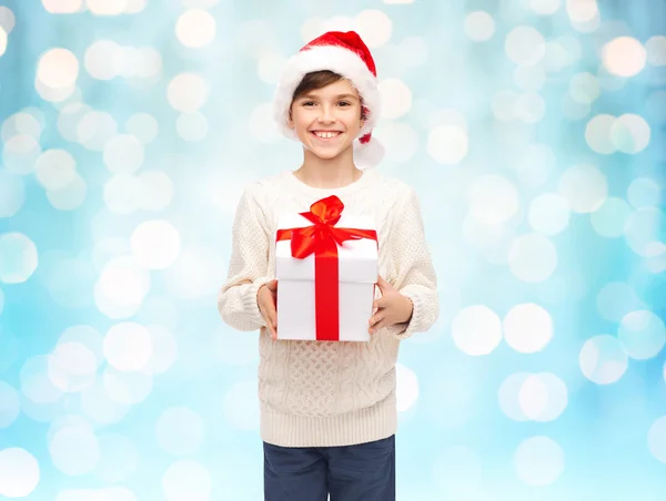 Smiling happy boy in santa hat with gift box — Stock Photo, Image