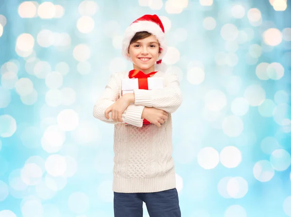 Noel Baba şapkalı hediye kutusu ile mutlu çocuk gülümseyen — Stok fotoğraf