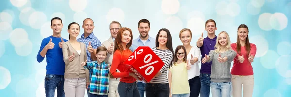 Щасливі люди червоний знак відсотка показує великі пальці вгору — стокове фото