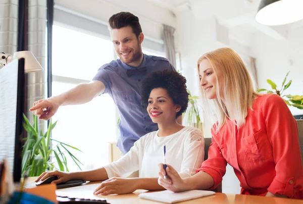 Equipe criativa feliz com computador no escritório — Fotografia de Stock