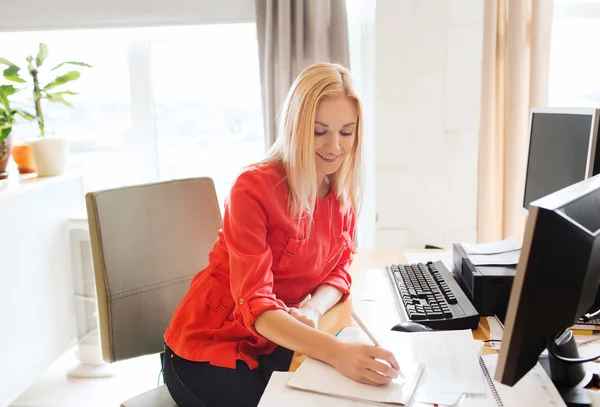 Творческая женщина, пишущая в ноутбук на работе — стоковое фото