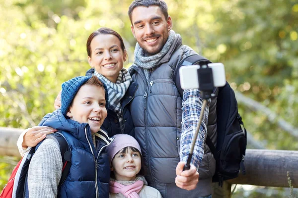 Lycklig familj med smartphone selfie pinne i skogen — Stockfoto