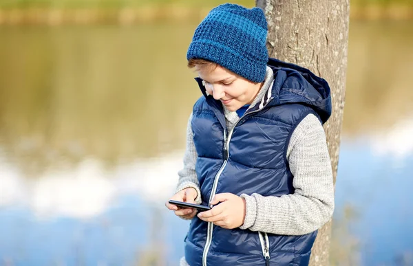 Boldog fiú játék a szabadban smartphone — Stock Fotó