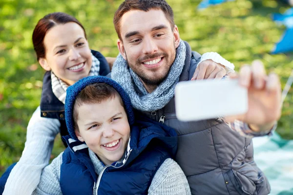 Família com smartphone tomando selfie no parque de campismo — Fotografia de Stock