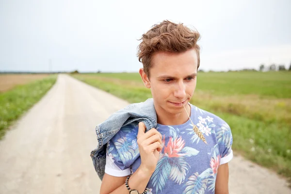 Triste giovane hippie che cammina lungo la strada di campagna — Foto Stock