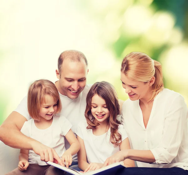 Família feliz com livro em casa — Fotografia de Stock