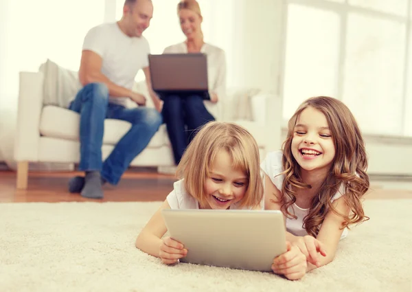 Irmã sorridente com tablet pc e pais nas costas — Fotografia de Stock