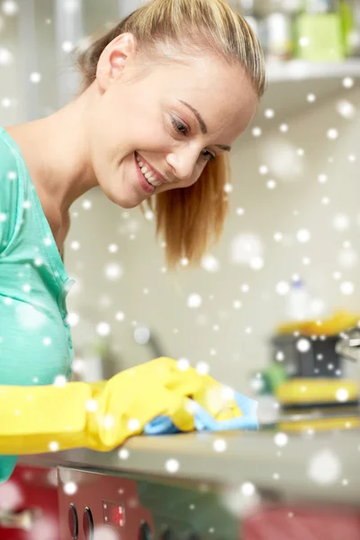Щаслива жінка прибирає плиту на домашній кухні — стокове фото