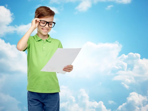 Happy boy in eyeglasses holding school test result — Stockfoto