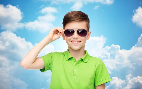 Garçon souriant dans les lunettes de soleil et le t-shirt de polo vert — Photo