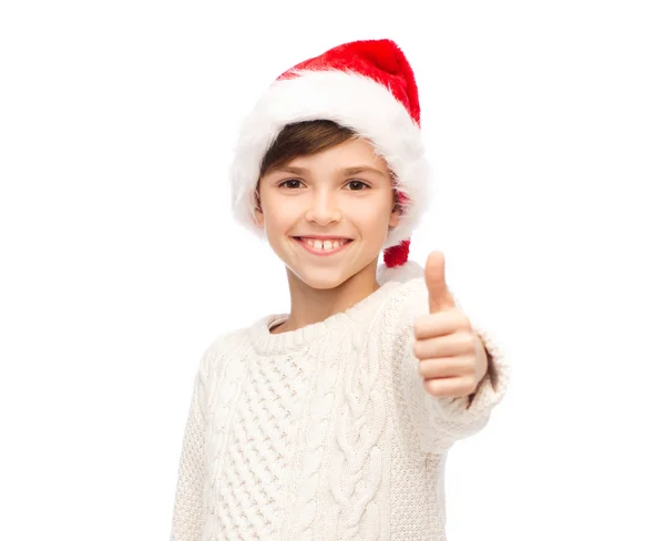 Sonriente feliz chico en santa sombrero mostrando pulgares hacia arriba — Foto de Stock