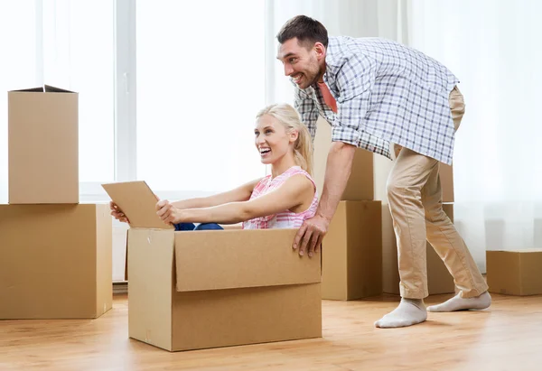 Couple with cardboard boxes having fun at new home — Stock Photo, Image