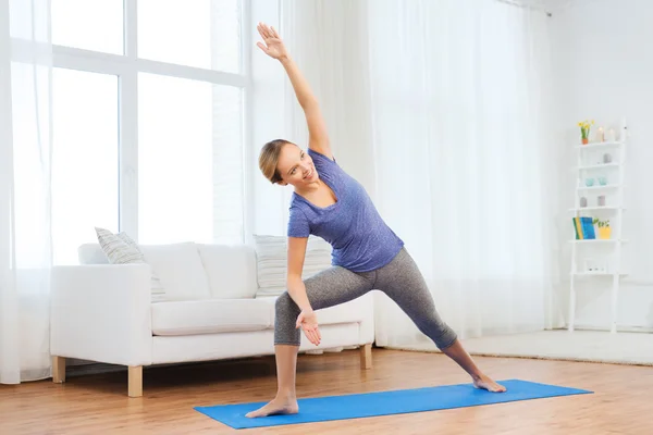 Mulher fazendo ioga bikram triângulo pose no tapete — Fotografia de Stock
