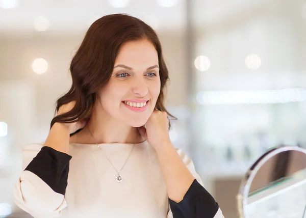 Mujer feliz elegir colgante en la joyería — Foto de Stock