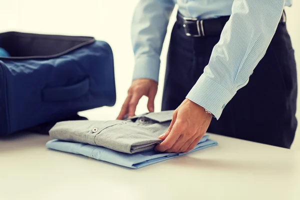 Homem de negócios embalando roupas em saco de viagem — Fotografia de Stock