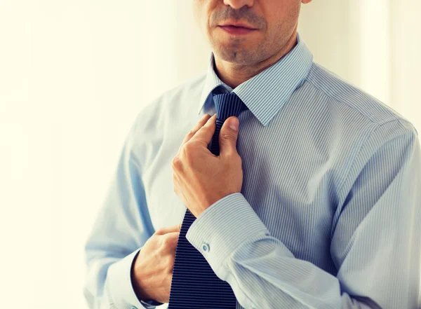 Close up of man in shirt adjusting tie on neck — Stock Photo, Image