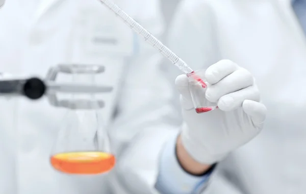 Primer plano de los científicos que llenan el tubo de ensayo en laboratorio — Foto de Stock