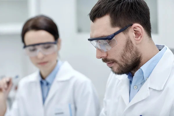 Close up of young scientists at laboratory — Stockfoto