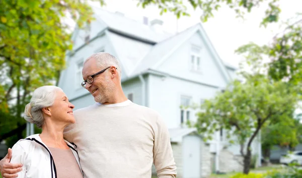 Senior couple hugging over living house background — Zdjęcie stockowe