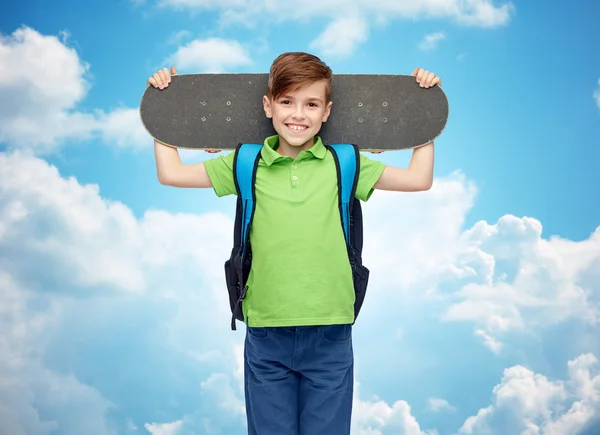 Szczęśliwy student chłopiec z plecakiem i deskorolką — Zdjęcie stockowe