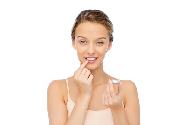 Souriant jeune femme appliquant baume à lèvres à ses lèvres — Photo