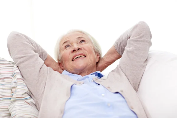 Heureuse femme âgée reposant sur le canapé à la maison — Photo