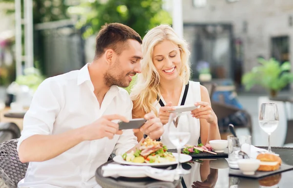 Szczęśliwa para z smatphone fotografowanie żywności — Zdjęcie stockowe