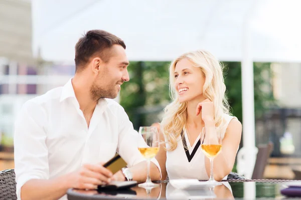 Feliz pareja con tarjeta bancaria y factura en el restaurante — Foto de Stock