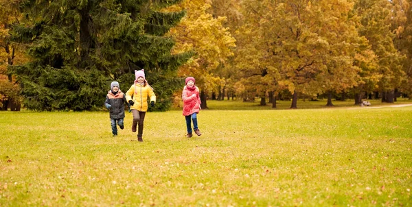 Skupina happy malé dětí běhá venku — Stock fotografie
