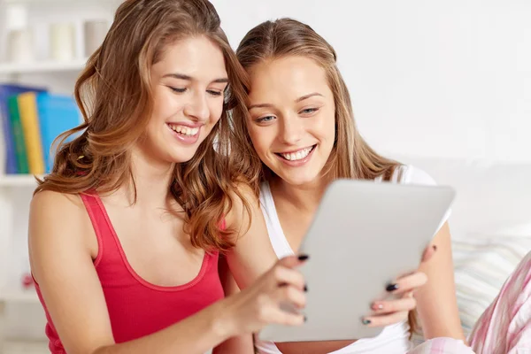 Happy friends or teen girls with tablet pc at home — Stock Photo, Image