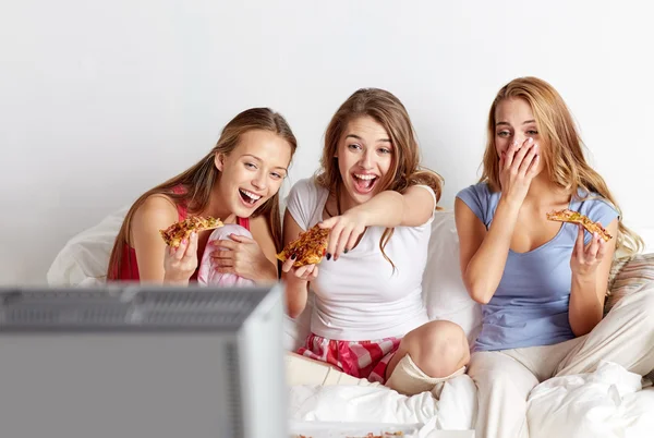 Amigos felices comiendo pizza y viendo la televisión en casa — Foto de Stock