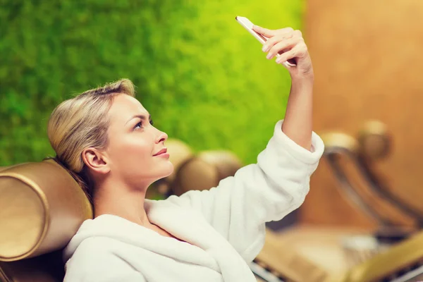 Belle jeune femme avec smartphone au spa — Photo