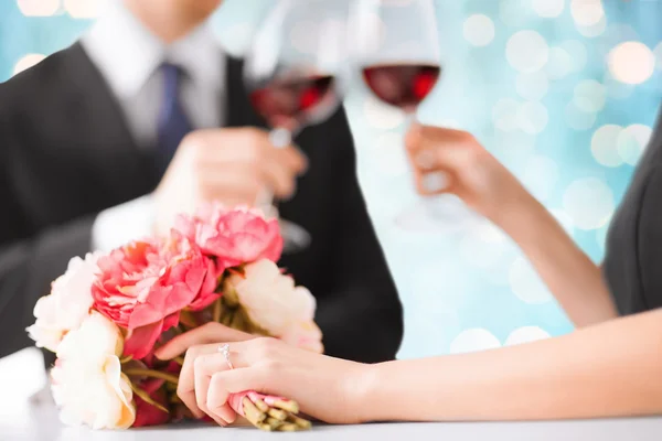 Happy engaged couple with flowers and wine glasses — Stock Photo, Image