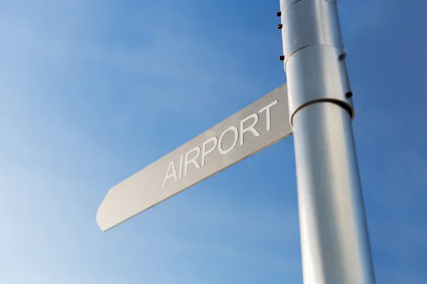 Close up of airport signpost over blue sky — Stock Photo, Image