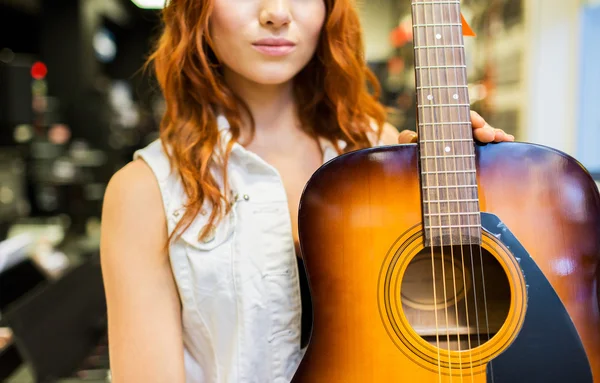 Närbild på kvinna med gitarr på musikaffär — Stockfoto