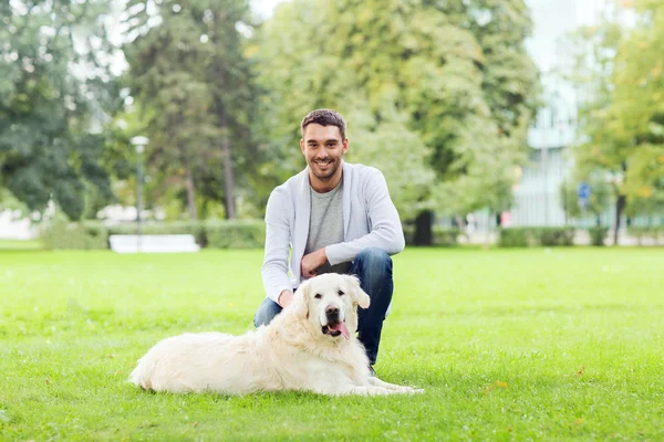 Счастливый человек с собакой-лабрадором, гуляющей по городу — стоковое фото