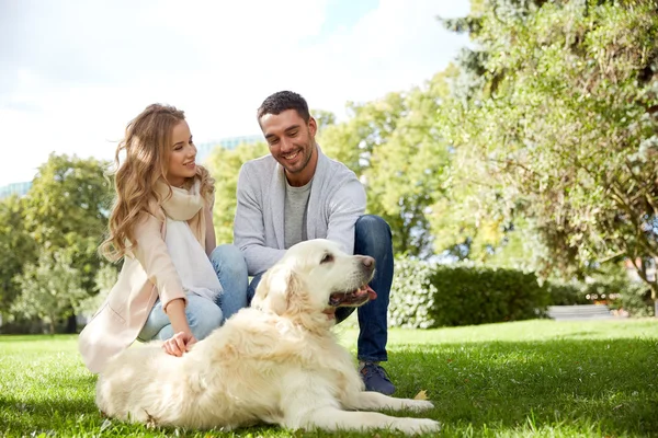 Happy couple with labrador dog walking in city — Stock Photo, Image