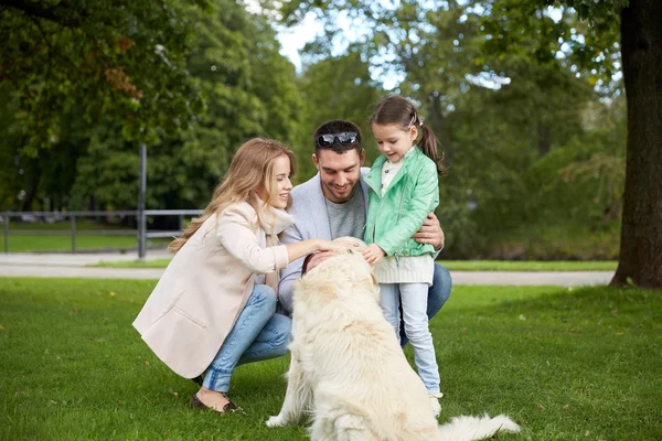 Ευτυχισμένη οικογένεια με Λαμπραντόρ Retriever Dog στο πάρκο — Φωτογραφία Αρχείου