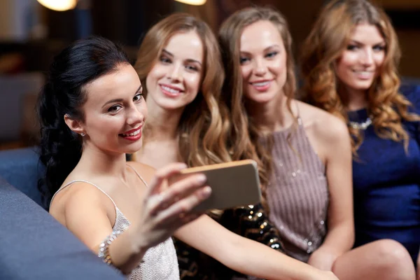 Women with smartphone taking selfie at night club — Stock Photo, Image