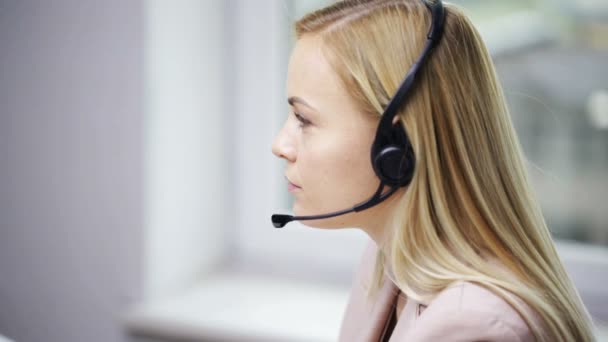 Geschäftsfrau mit Headset redet im Büro — Stockvideo