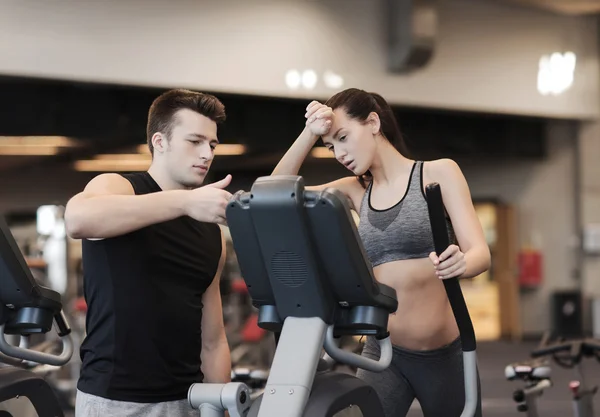 Kvinna med tränare utövar på stepper i gym — Stockfoto