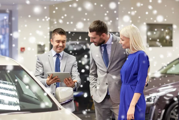 Glückliches Paar mit Autohändler in Auto-Show oder Salon — Stockfoto