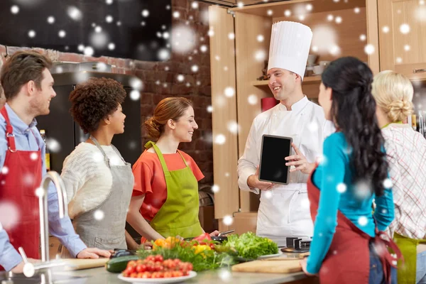 Glückliche Freunde mit Koch und Tablet-PC in der Küche — Stockfoto