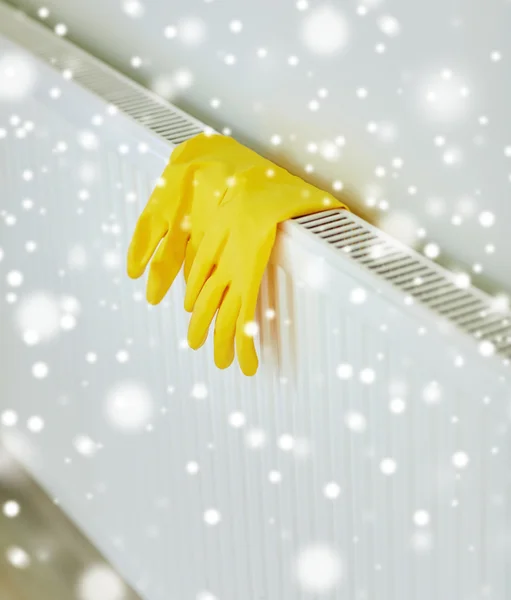 Close up of rubber gloves hanging on heater — Stock Photo, Image