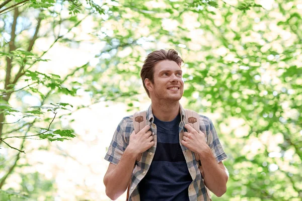 Sonriente joven con mochila senderismo en el bosque —  Fotos de Stock