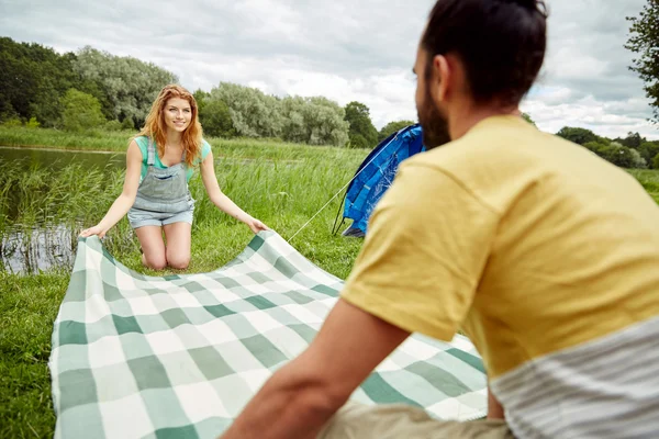 Heureux couple pose couverture de pique-nique au camping — Photo