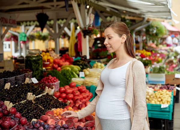 Mujer embarazada eligiendo comida en el mercado callejero — Foto de Stock