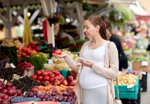 Mujer embarazada con smartphone en el mercado callejero — Foto de Stock