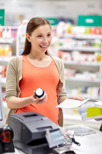 Happy pregnant woman with medication at pharmacy — Stock Photo, Image